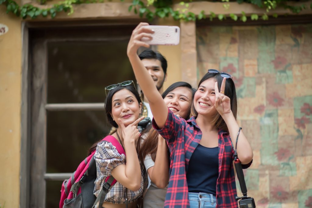 group of friends taking selfie in a urban street having good fun