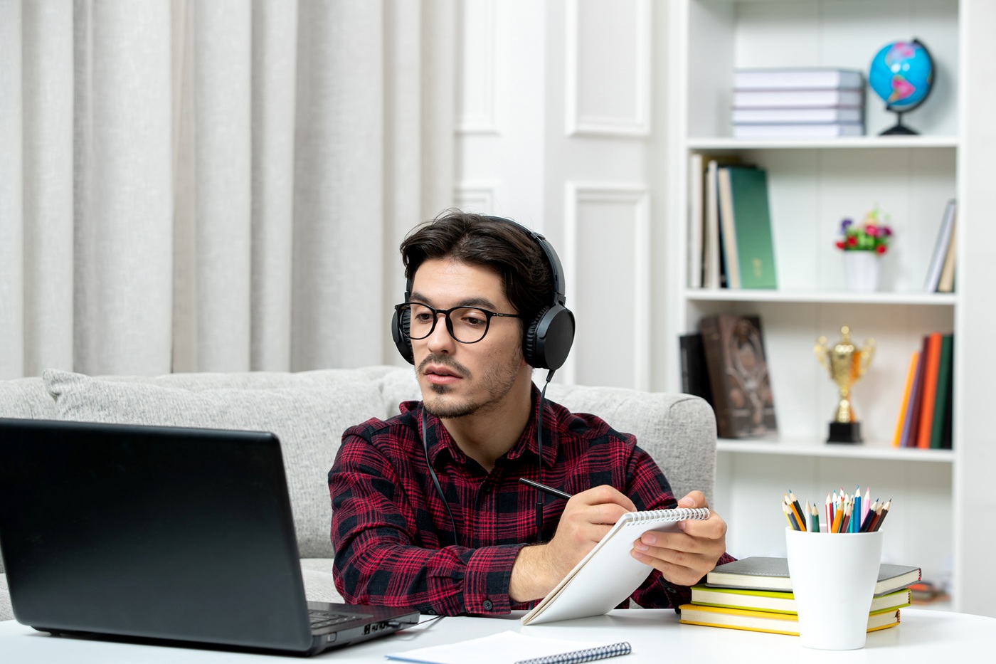 student online cute guy checked shirt with glasses studying computer writing down notes