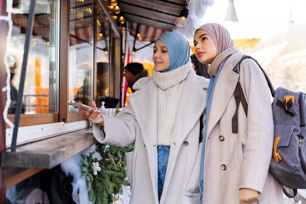 Discover two muslim women checking out pastry shop while traveling 23 2149275763